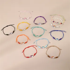 Bunte geflochtene Regenbogen Armbänder Detailansicht mit verschiedenen Perlen und Anhängern.