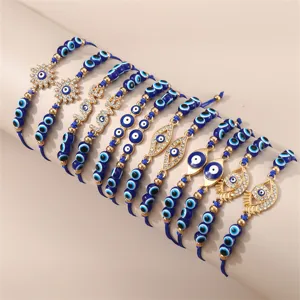 Detailansicht blauer Perlenarmbänder mit bösem Blick, Goldanhängern und funkelnden Strasssteinen.