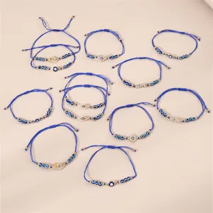 Detailaufnahme blauer geflochtener Armbänder mit bösem Blick und Liebesperlen für trendigen Schmuck.
