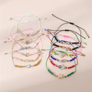 Detailansicht modischer geflochtener Perlen-Charm-Armbänder für Damen mit bösem Blick und Perlen.