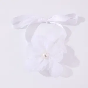 Dettaglio fiore da polso in nastro di tessuto bianco, elegante bracciale sposa con perla.