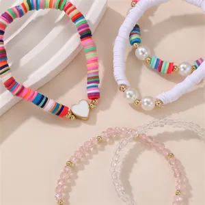 Nahaufnahme eines handgefertigten bunten Perlenarmband-Sets aus Fimo und Kristall.