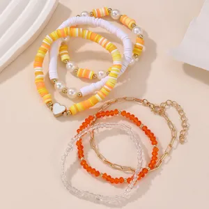 Detailaufnahme des bunten Tonperlen Armband-Sets mit weißem Herzanhänger und Perlen.