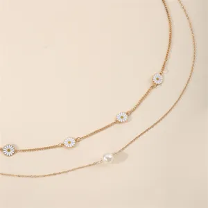 Detailansicht der goldenen Taillenkette mit weißen Gänseblümchen und Perle für den Sommer.
