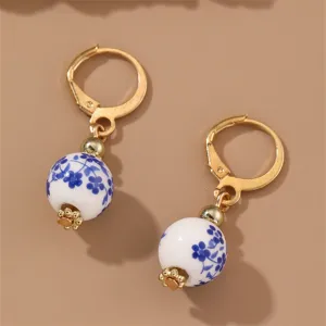 Charming blue and white porcelain floral drop earrings with retro gold-tone hoop design.