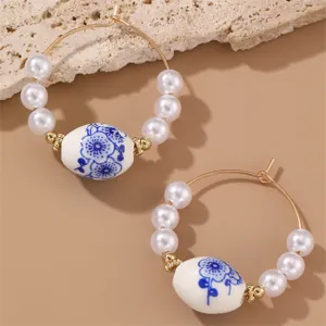 Close-up of blue and white porcelain bead pearl hoop earrings, vintage style detail view.