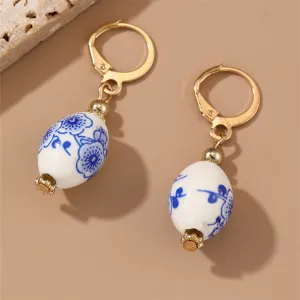 Elegant blue and white porcelain dangle earrings featuring retro floral design and gold tone hooks.