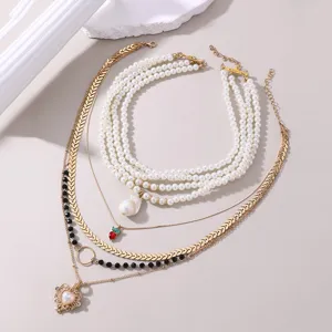 Mehrlagige Perlen-Choker-Halskette mit goldenen Fischgrätketten und Herzanhänger.