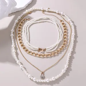 Mehrlagiges Perlenketten-Set mit klobigen Goldketten und Strass-Herzschloss-Anhänger für Damen.