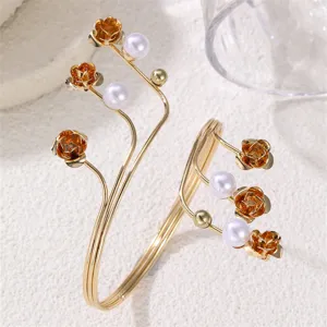 Bracciale rigido da braccio floreale in metallo dorato con perle, gioiello trendy chic.