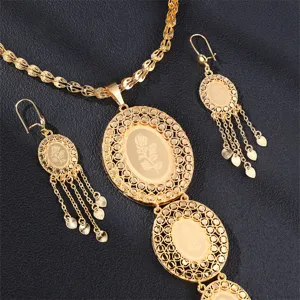 Nahaufnahme des goldenen hohlen Blumenmuster-Anhängerhalsbands und passender Ohrringe.