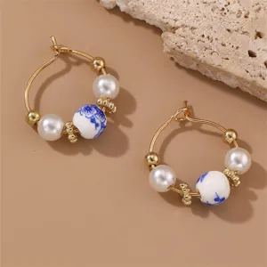 Close-up detail view of vintage Chinese style blue and white porcelain pearl hoop earrings.