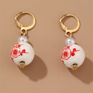 Detail shot of retro Chinese style ceramic bead drop earrings with gold tone leverback hooks.
