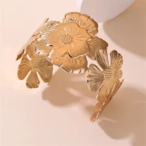 Goldfarbenes Blumen Metall Manschettenarmband, breiter Statement Modeschmuck für Damen.