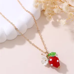 Gold-tone chain necklace featuring a cute red resin strawberry pendant and white flower charm.