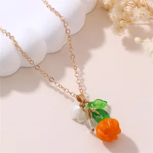 Close-up of a gold-tone chain necklace featuring colorful resin fruit & flower pendants.