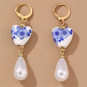 Vintage blue and white porcelain heart dangle earrings with elegant faux pearl pendants.