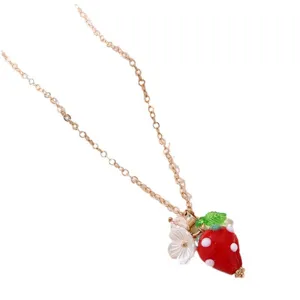 Gold-tone chain necklace featuring a cute red resin strawberry pendant with white dots and flowers.