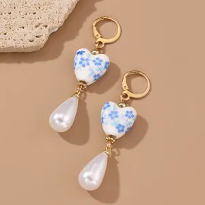 Blue and white porcelain ceramic heart pearl drop earrings, retro vintage style detail view.