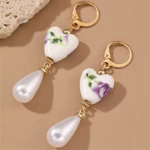 Vintage gold-plated leverback earrings featuring ceramic floral heart pendants and white faux pearls.