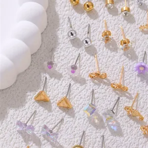 Nahaufnahme von verschiedenen kleinen Ohrstecker Sets mit Blumen und schönen geometrischen Formen.