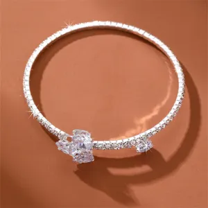 Silberfarbenes Strass Manschettenarmband mit glitzerndem Kristallblumen Detail.