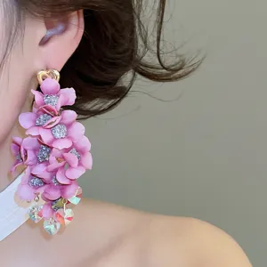 Detail shot of pink fabric flower drop earring with glitter center and heart charms.