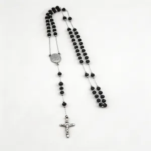 Detailed view of the black faceted bead rosary necklace featuring a classic silver cross pendant.