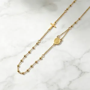 Collier avec perles et croix dorée, chaîne clavicule en acier inox gros plan vue.