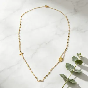 Collier chapelet en acier inoxydable doré avec pendentif croix délicat et médaille ronde.