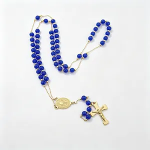 Elegant blue bead rosary necklace featuring a gold tone crucifix and central medal pendant.