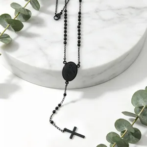 Detailed shot of the black stainless steel rosary necklace featuring beaded chain and cross pendant.