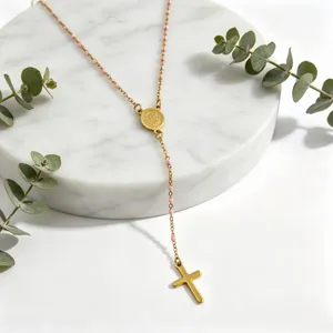 Gold stainless steel rosary necklace with pink beads and cross pendant, elegant jewelry.