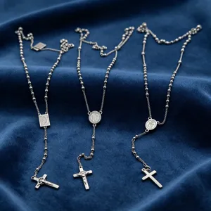 Detailed view of vintage stainless steel beaded chain necklaces with cross religious pendants.