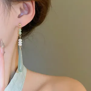 Primo piano dettagliato dell'orecchino pendente con perla e resina, molto elegante.