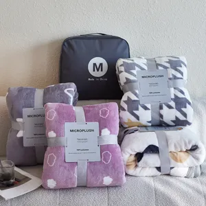 Gevouwen micropluche flanellen dekens in verschillende patronen met labels en tas.