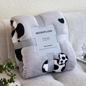Gefaltde grijze micropluche flanellen deken met schattig koeprint patroon en papieren label