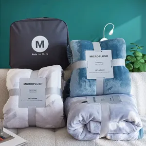Gedetailleerd overzicht van gevouwen microplush flanellen dekens met een grijze opbergtas
