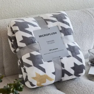 Dichtbij opname van een gevouwen microplush deken met pied-de-poule patroon