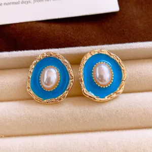 Detailed close-up view of elegant vintage blue enamel oval pearl earrings displayed nicely.