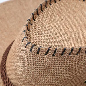 Close-up detail of western cowboy straw hat with braided band and black stitching craftsmanship.