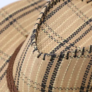 Close-up detail of a woven straw cowboy hat showing intricate weave texture and stitching.