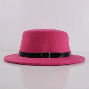 Vista dettagliata di un cappello di feltro rosa piatto con cintura nera e fibbia in metallo.