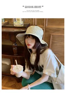 Close-up detail of the washed distressed bucket hat worn by model in cozy indoor setting.