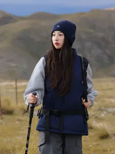 Outdoor knit beanie detail showing embroidered mountain logo, worn in mountain scenery.