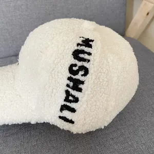 White sherpa baseball cap for women, cozy winter fleece hat with black embroidered text details.