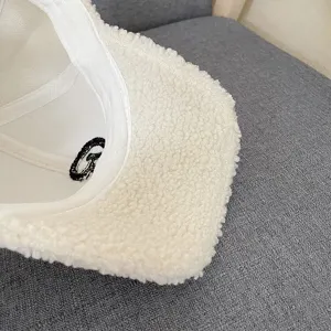 White sherpa baseball cap detail, cozy winter plush hat featuring interior letter embroidery.