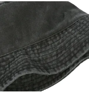 Denim bucket hat fabric detail showing retro washed black texture and precision brim stitching.
