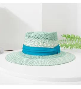 Closeup of the mint green woven straw hat with blue ribbon detail and exquisite craftsmanship.