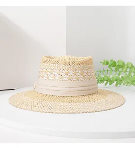Detailed view of the woven straw texture and chic beige ribbon on the summer sun hat.